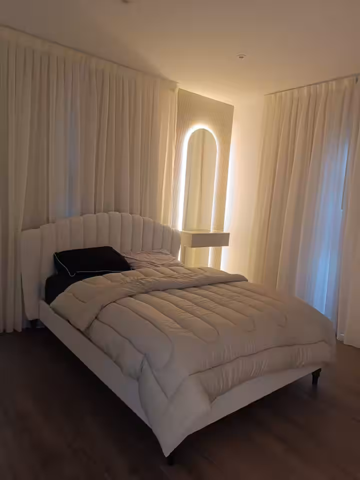 Master bedroom with a king bed, soft cove lighting and blackout curtains