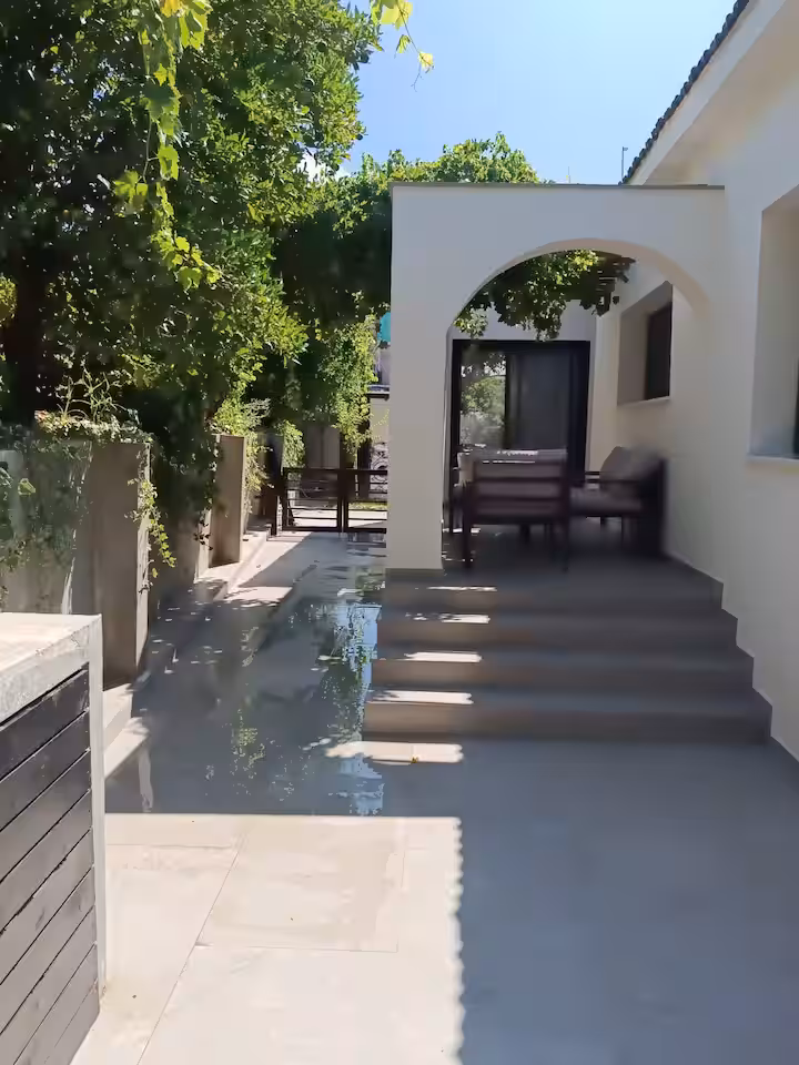 Arched garden walkway shaded by grapevines in the villa's garden